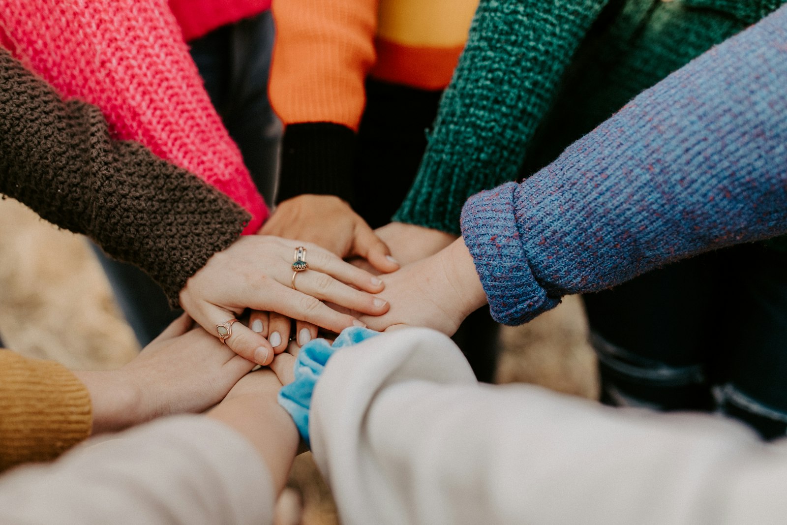 Diverse hands clasped together in a circle, symbolizing the bedrock of service